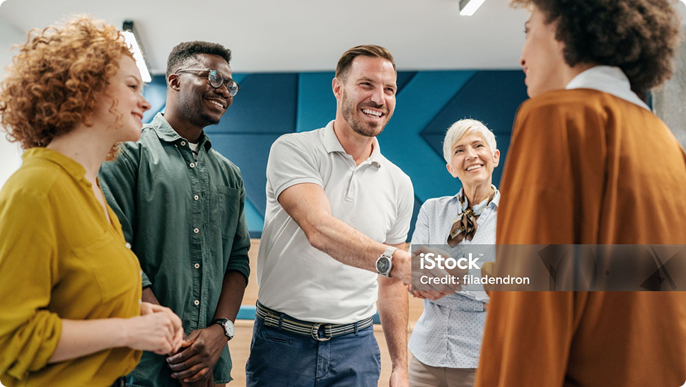 Eine Gruppe von Menschen begrüßen sich mit einem Handschlag